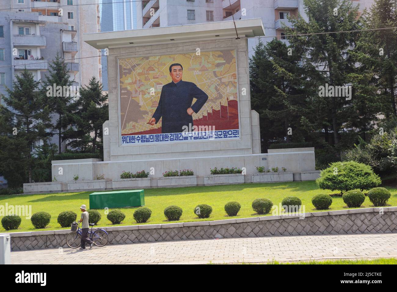 08.08.2012, Pjoengjang, North Korea, Asia - A daily street scene shows a memorial plaque with the portrait of Kim Il-sung and residential houses in the background. The personality cult around the two former leaders is still omnipresent and their pictures and statues appear all over the country. [automated translation] Stock Photo