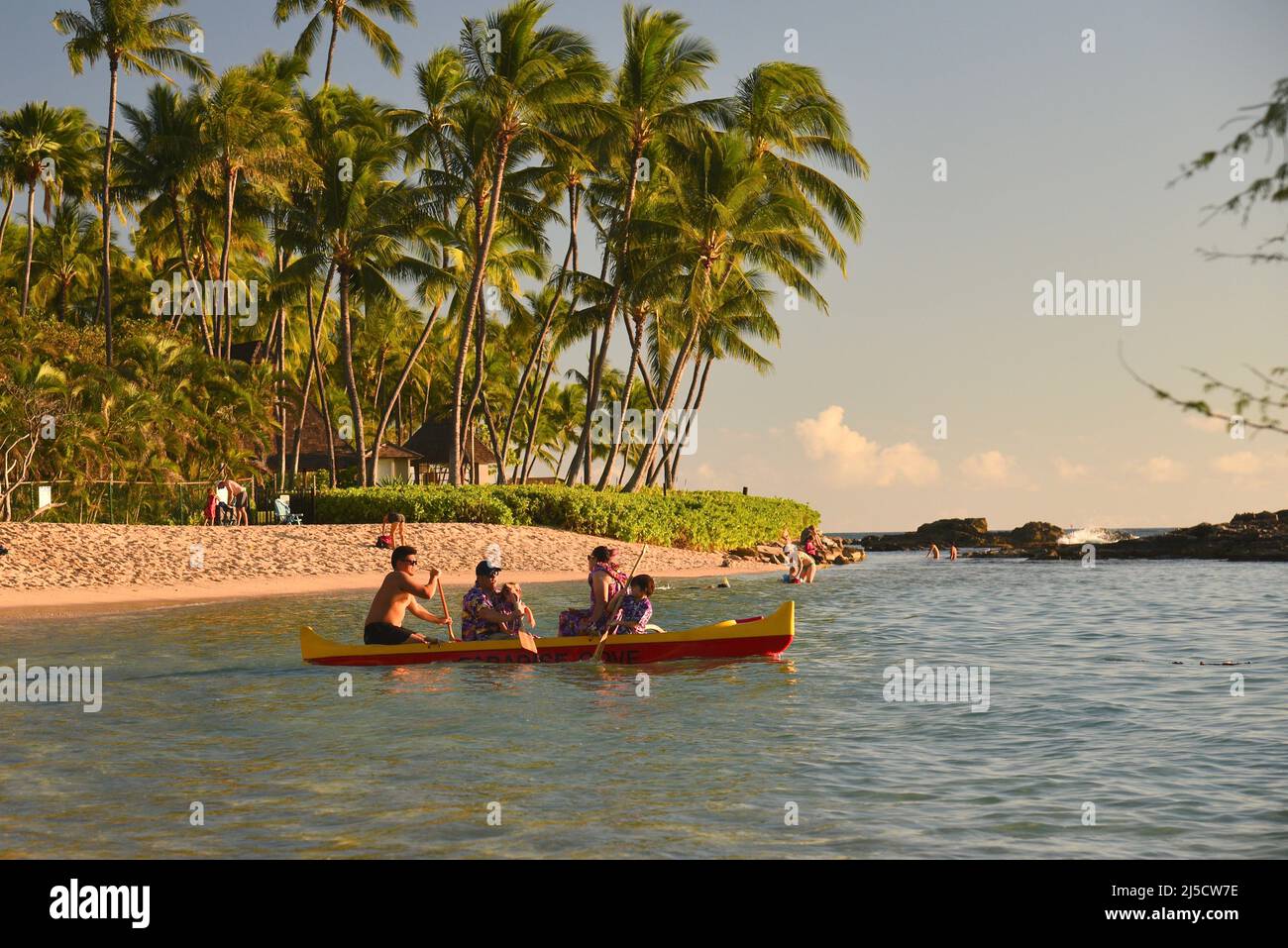 Guests paddling to going on Hawaiian outrigger canoe sunset ride as a