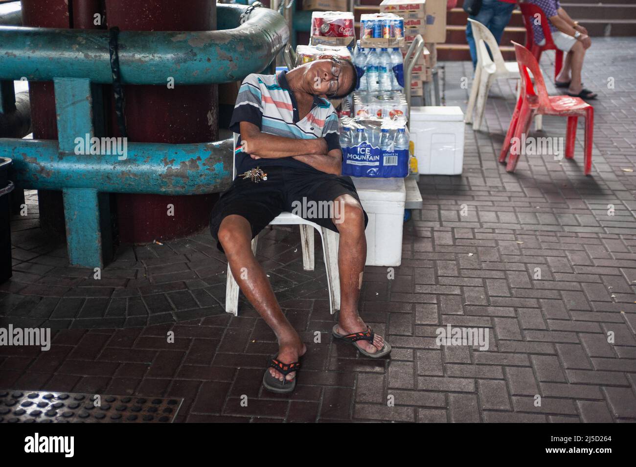 Jan. 17, 2020, Singapore, Republic of Singapore, Asia - An elderly man sleeps sitting in an awkward position on a chair in Chinatown, dislocating his neck. [automated translation] Stock Photo