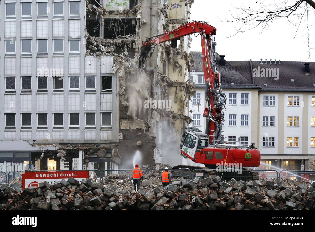 'Berlin, 15.12.2021 - An administrative building from the 60s is demolished with a demolition machine in the district of Berlin Schoeneberg. Here arises ''Am Winterfeldt'', with 7 buildings, 219 exclusive residential and 8 commercial units. [automated translation]' Stock Photo