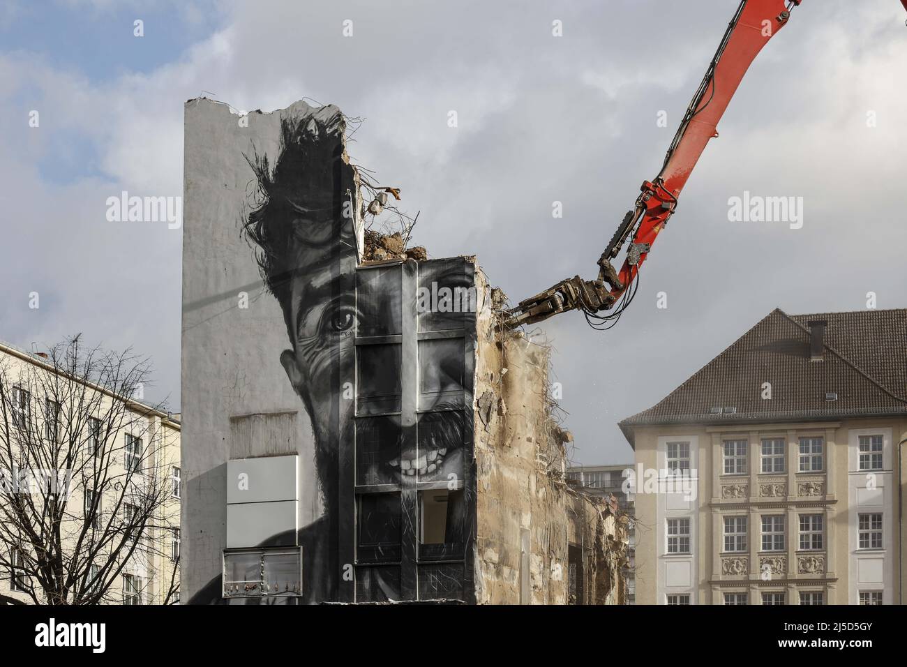 'Berlin, 07.02.2022 - An administrative building from the 60s is demolished with a demolition machine in the district of Berlin Schoeneberg. The last weeks before the demolition, the building was decorated with a portrait of the worker Miriam M., who was portrayed for the exhibition ''Eyes on Concrete''. [automated translation]' Stock Photo
