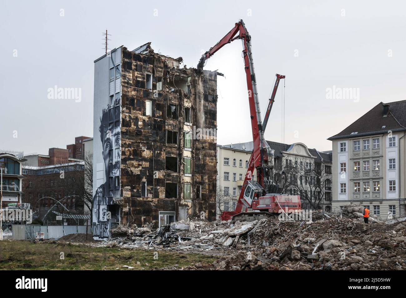'Berlin, 03.02.2022 - An administrative building from the 60s is demolished with a demolition machine in the district of Berlin Schoeneberg. Here arises ''Am Winterfeldt'', with 7 buildings, 219 exclusive residential and 8 commercial units. [automated translation]' Stock Photo