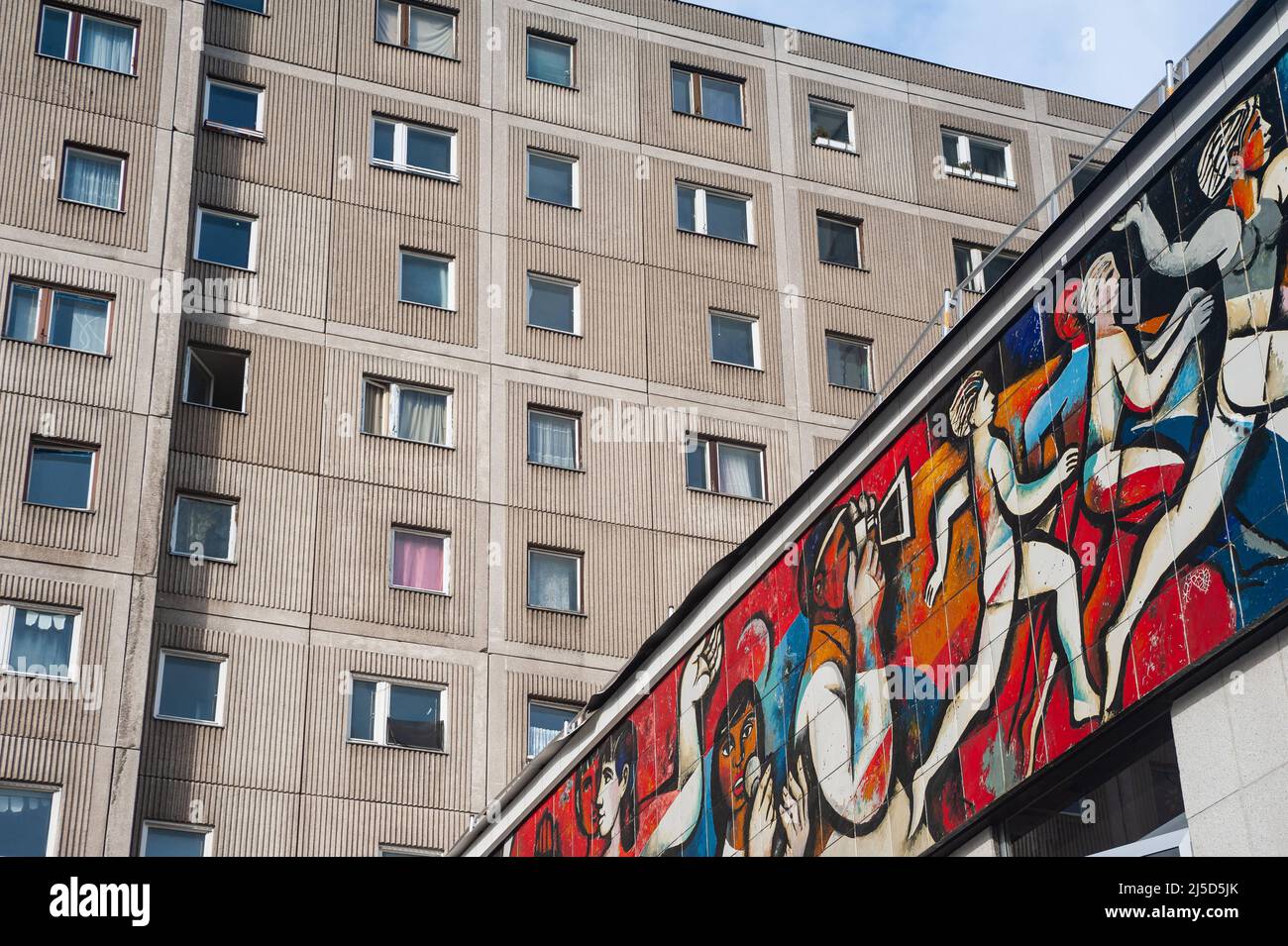 05.02.2022, Berlin, Germany, Europe - GDR frieze (wall mosaic) with the title The press as an organizer at the former Pressecafe Berlin flat building at Alexanderplatz by the painter Willi Neubert. Adjacent to it a typical prefabricated building with apartments. [automated translation] Stock Photo