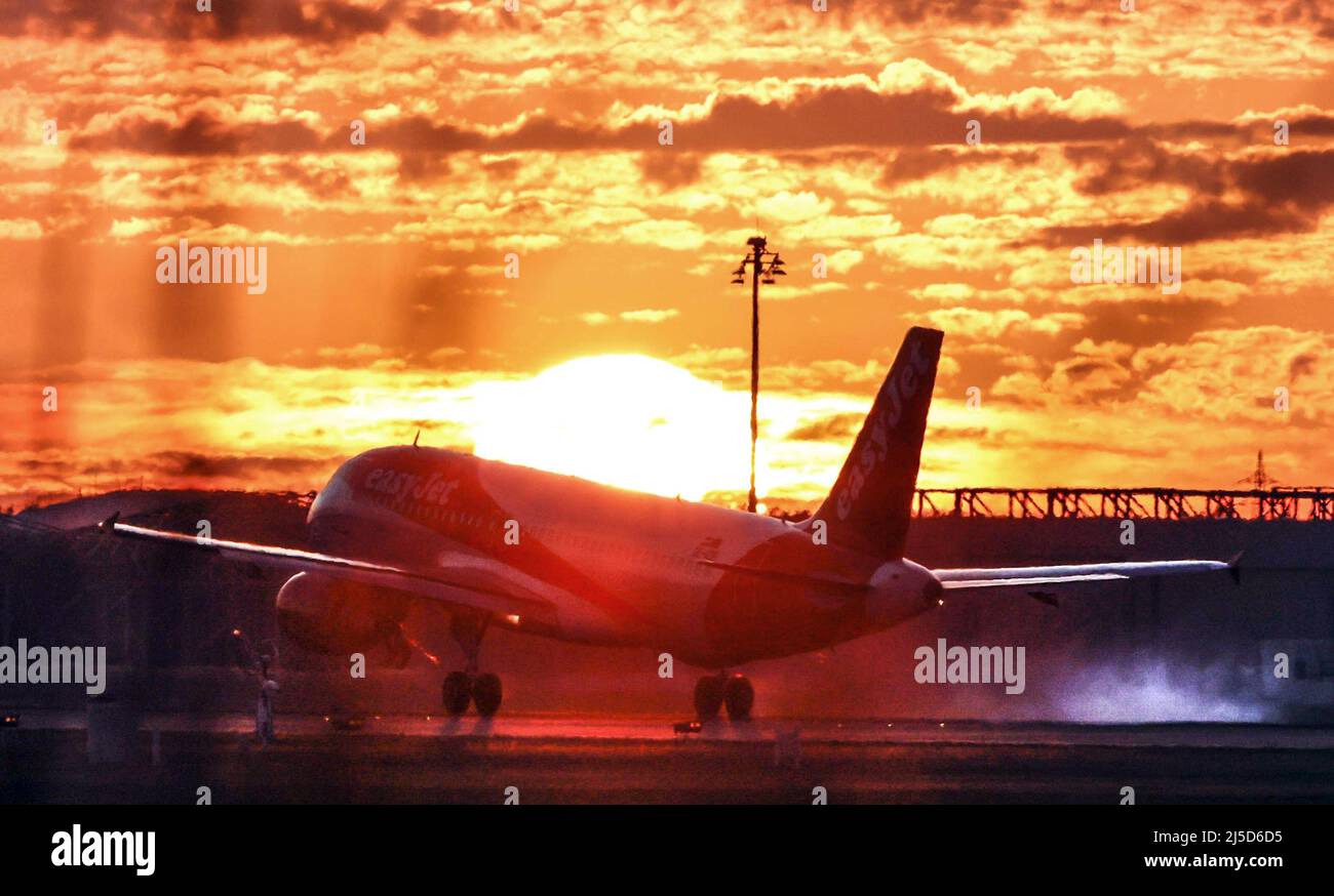 An easyJet Airbus takes off for sunset at BER Airport, Berlin Brandenburg. [automated translation] Stock Photo