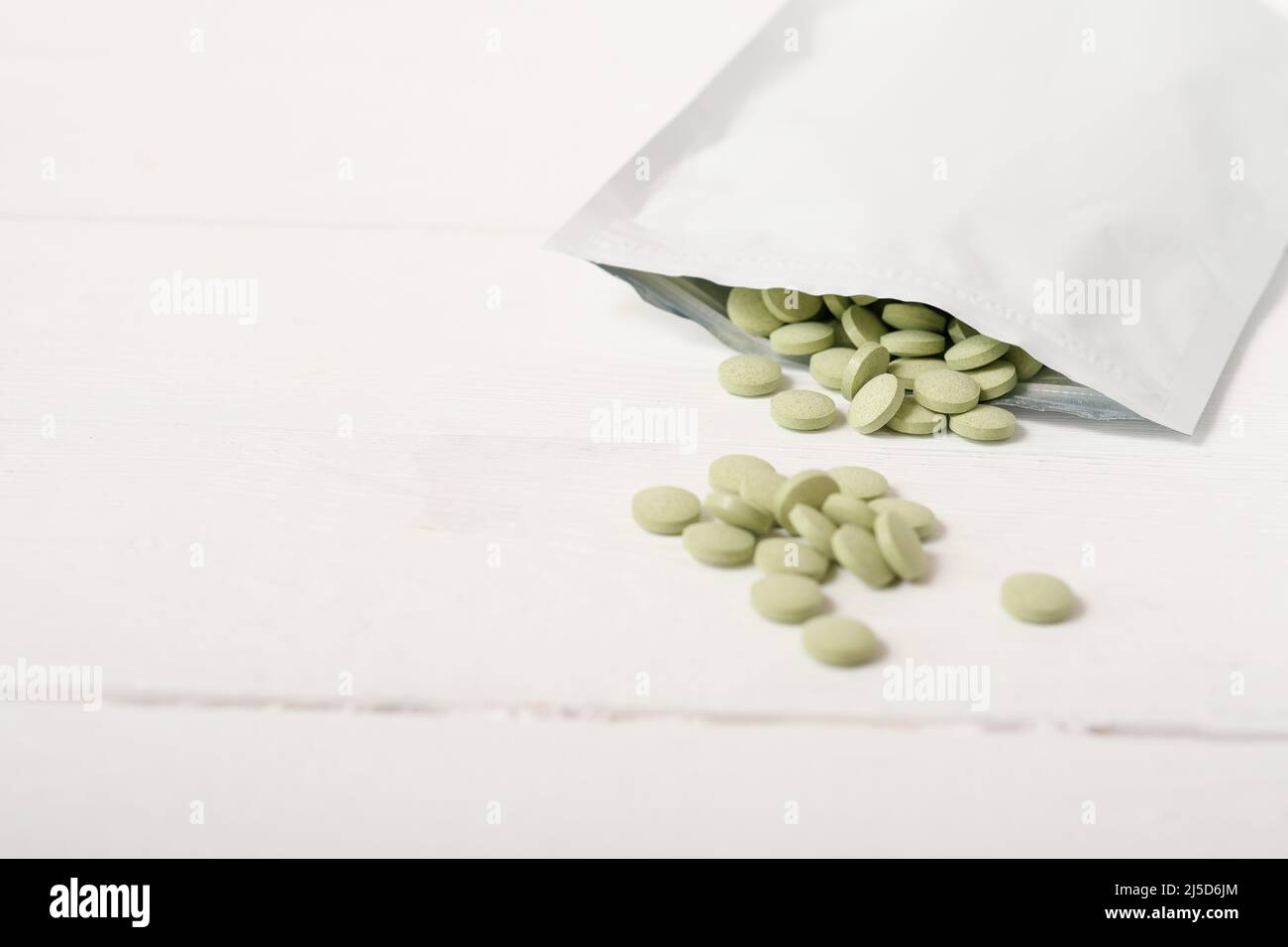 barley grass pills on a table in a zip package. Spirulina and chlorella