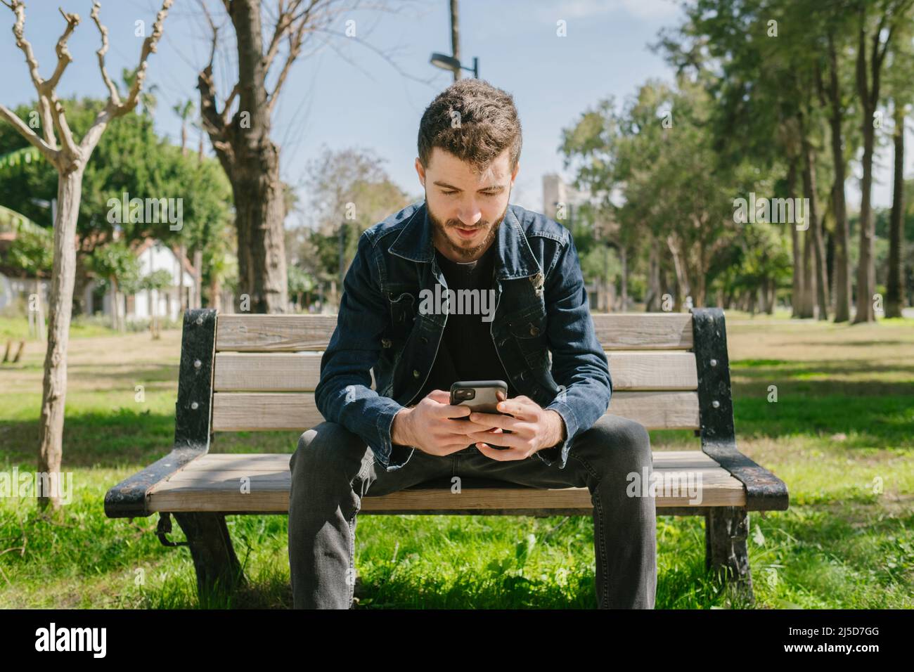 Premium Photo  Young bearded man in sunglasses sitting on a wooden park  bench planning his next chess move
