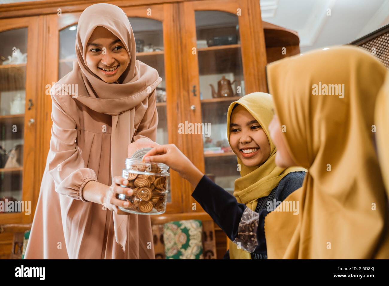 Snacks Giving woman giving a snacks to her guest during idul fitri family visit Stock ...
