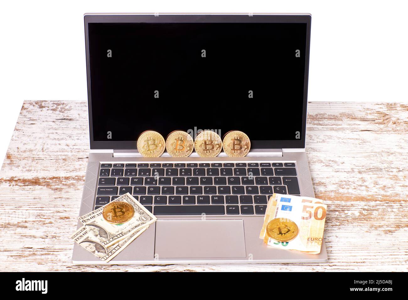 Bitcoin, Euro and dollar bills on a laptop on an office desk. Payment with cryptocurrencies, using virtual currency. Internet economy concept Stock Photo