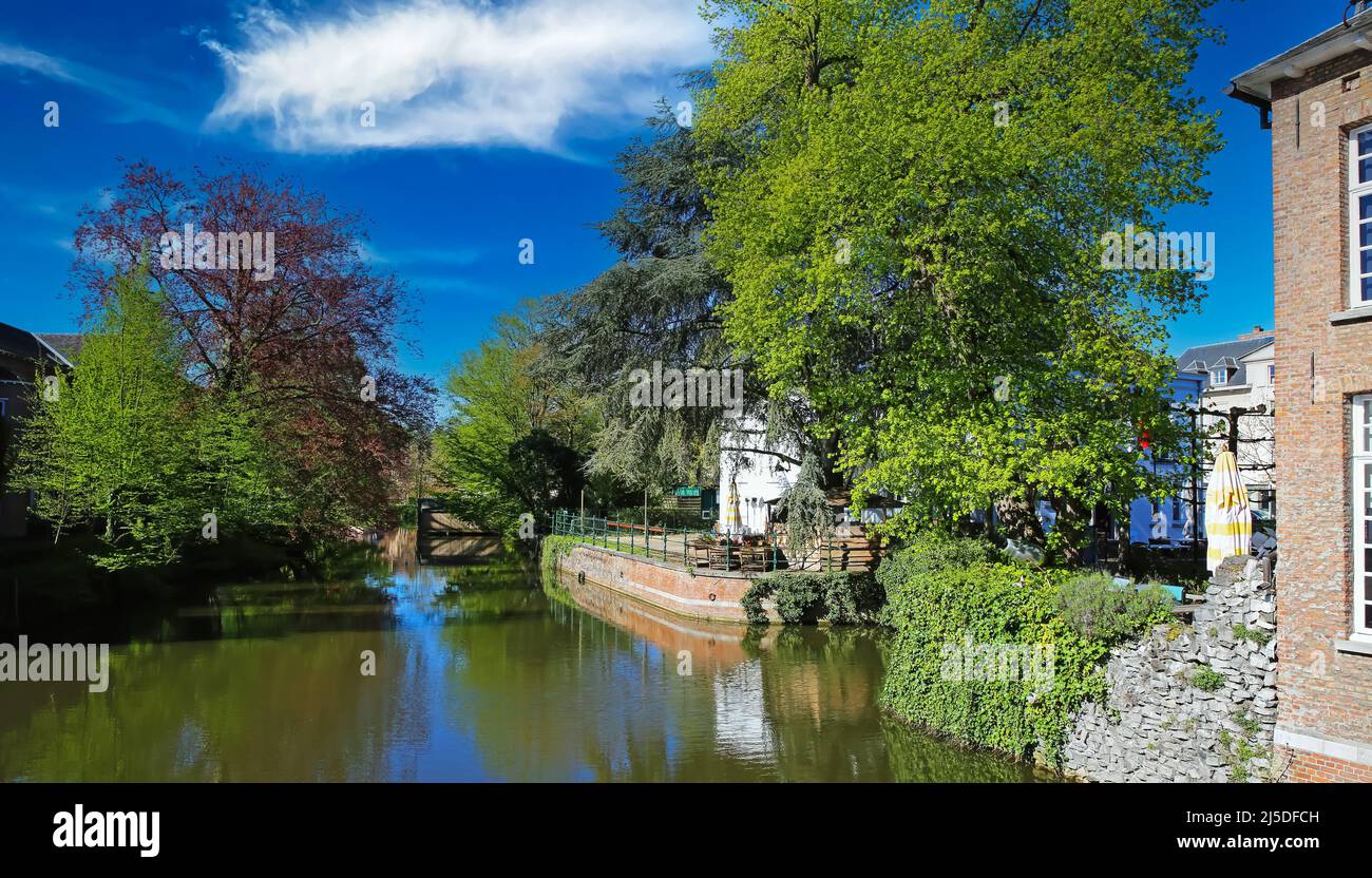 Lier, Belgium - April 9. 2022: View over idyllic romantic water town moat on medieval houses, green trees park, blue sky Stock Photo