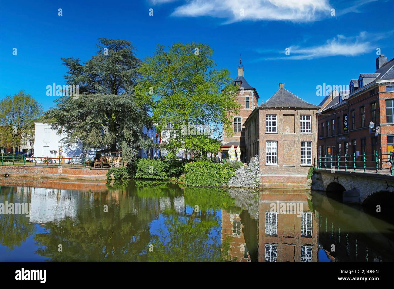 Lier, Belgium - April 9. 2022: View over idyllic romantic water town moat on medieval houses, green trees park, blue sky Stock Photo