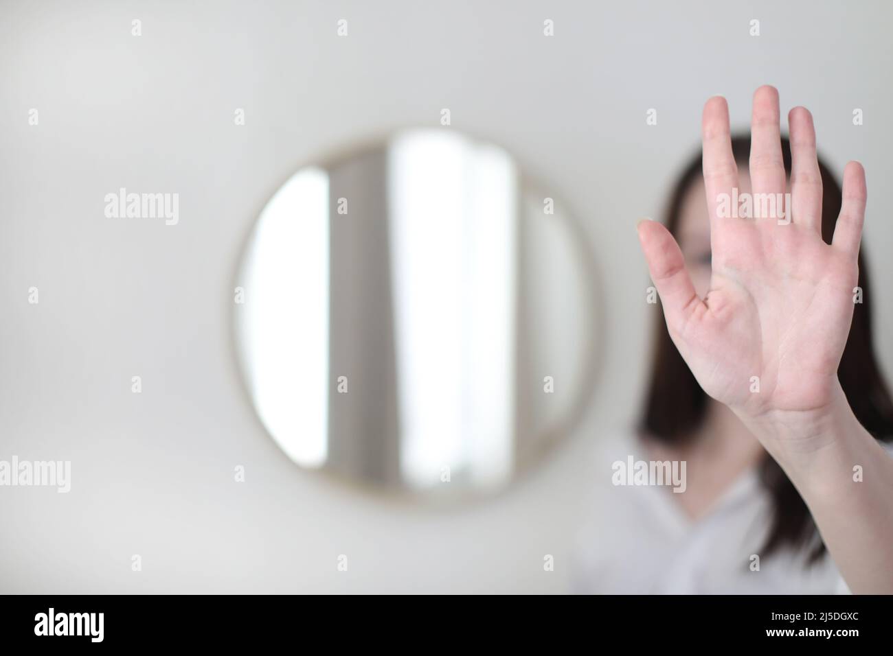 young woman looking in the mirror. Mental health problems in self-isolation at home. Depression, anxiety, phobia, suicide and mental health concept. Stock Photo