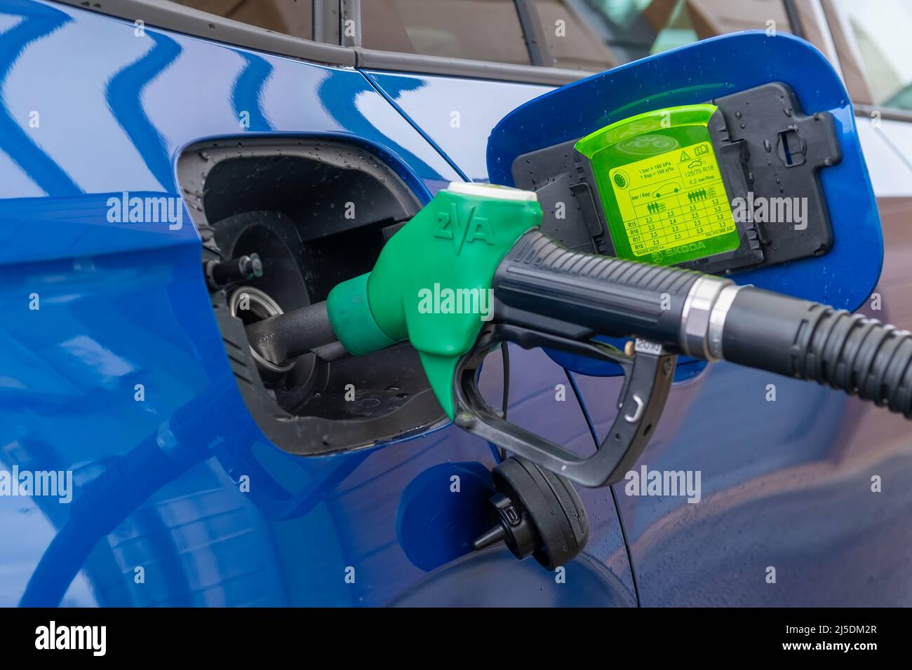 Refilling of blue modern Skoda car at petrol station with gasoline. Increasing price and oil embargo concept, April 2022, Prague, Czech Republic Stock Photo