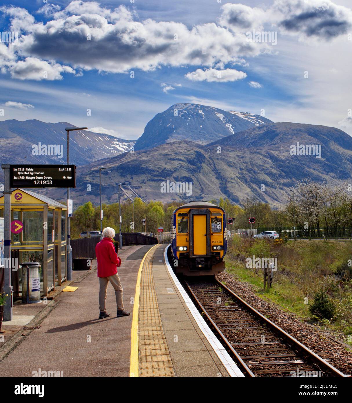 FORT WILLIAM SCOTLAND SCOTRAIL WEST HIGHLAND RAILWAY LINE PASSENGER WAITING FOR TRAIN ARRIVING AT BANAVIE STATION AND VIEW OF BEN NEVIS Stock Photo