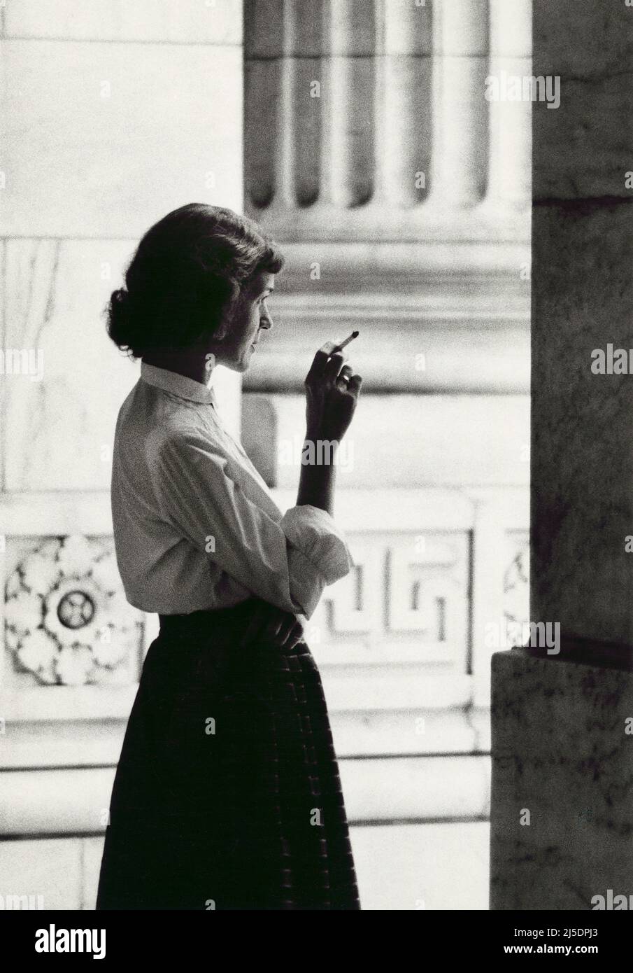 Woman wearing Blouse and Long Skirt smoking a Cigarette outside New York Public Library, Fifth Avenue Entrance, New York City, New York, USA, Angelo Rizzuto, Anthony Angel Collection, August 1954 Stock Photo