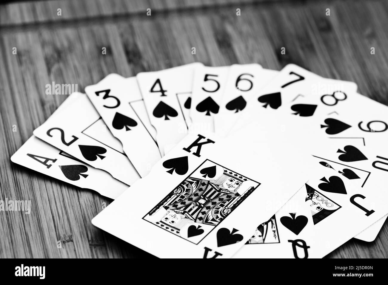 Fan of playing cards close up, isolated on wooden table. Casino concept, risk, chance, good luck or gambling. Stock Photo
