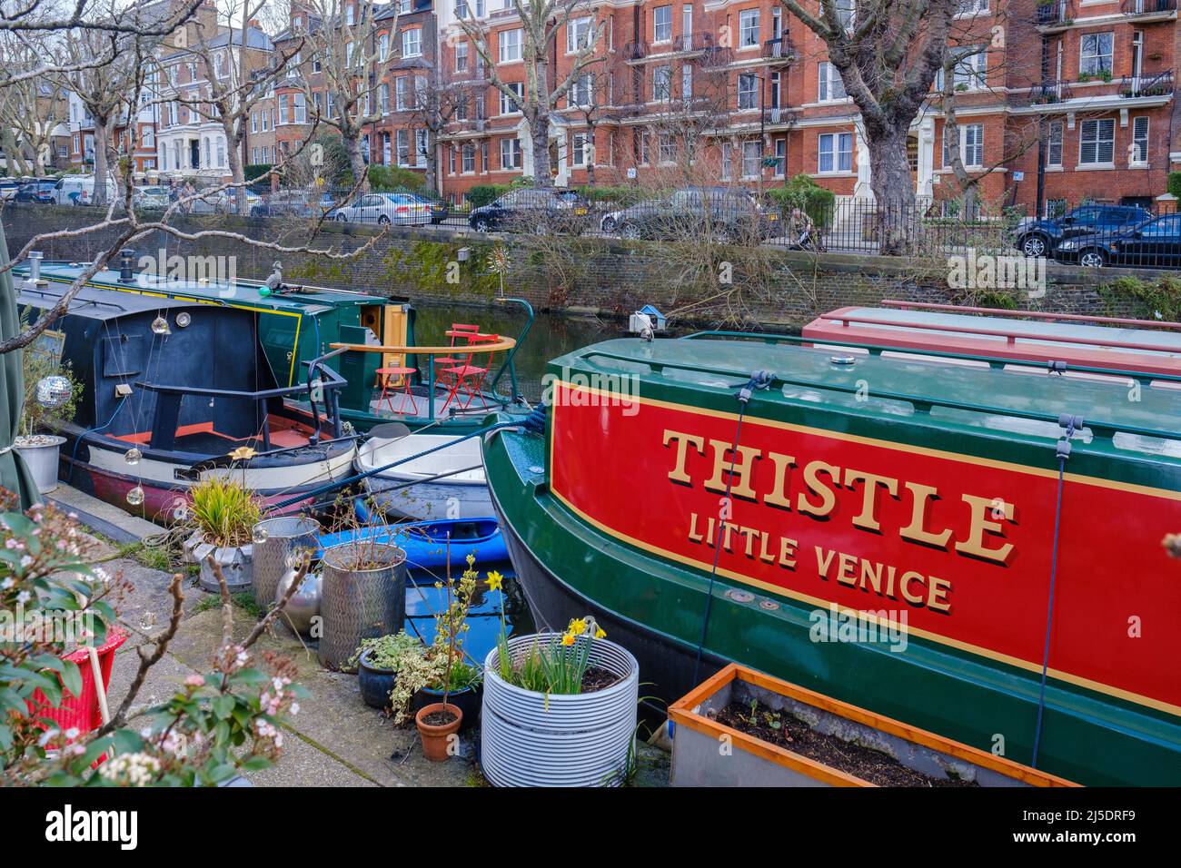 The Thistle narrowboat docked at Little Venice, Regent’s Canal. Maida Avenue & a stately mansion block in the background. West London, England, UK. Stock Photo