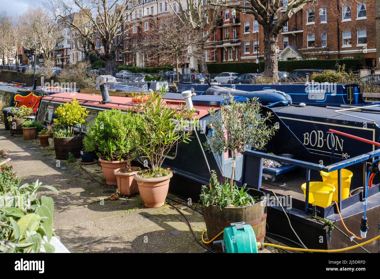 Narrowboats docked at Little Venice, Regent’s Canal, with Maida Avenue and a stately mansion block in the background, West London, England, UK. Stock Photo