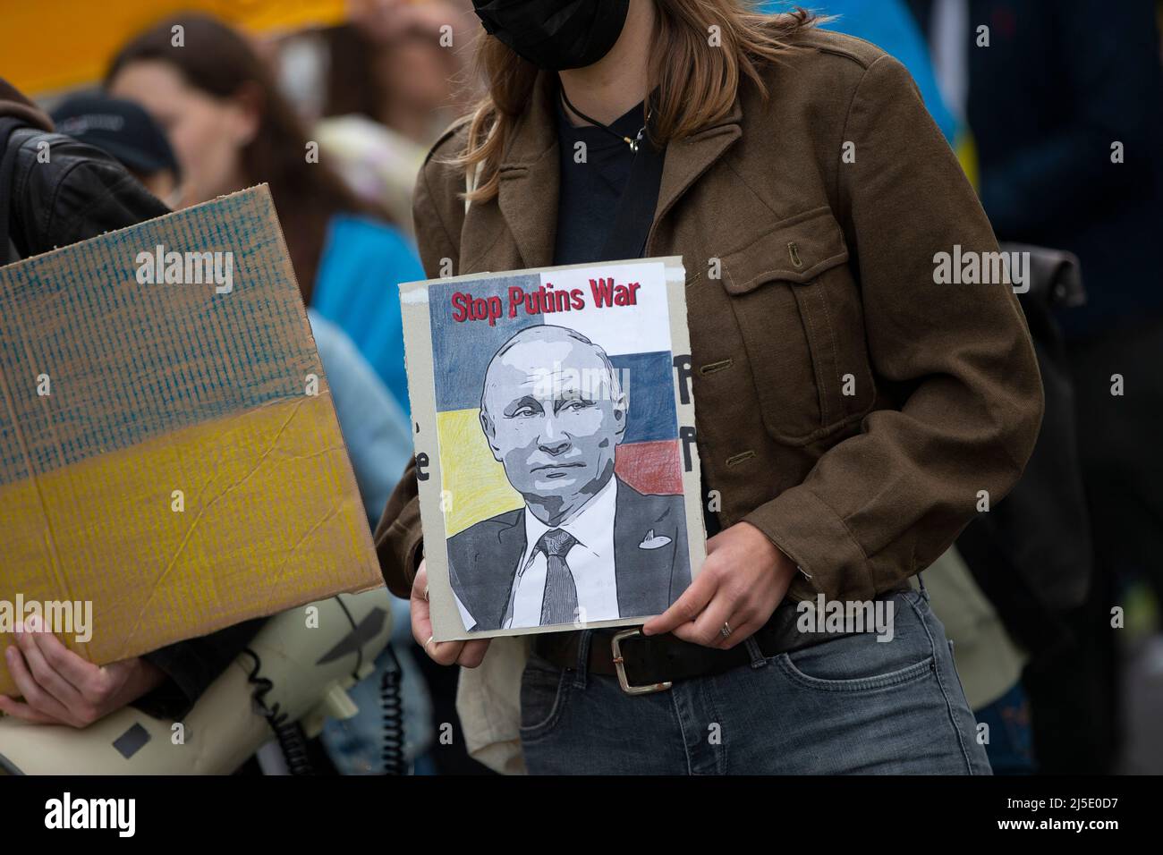 Bonn, Germany. 22nd Apr, 2022. A participant holds a sign with the inscription: 'Stop Putin's War'. On Friday evening, about 100 demonstrators marched through the center of Bonn to protest against the war in Ukraine. The demonstration started and ended at the Hofgarten in Bonn. Credit: Thomas Banneyer/dpa/Alamy Live News Stock Photo