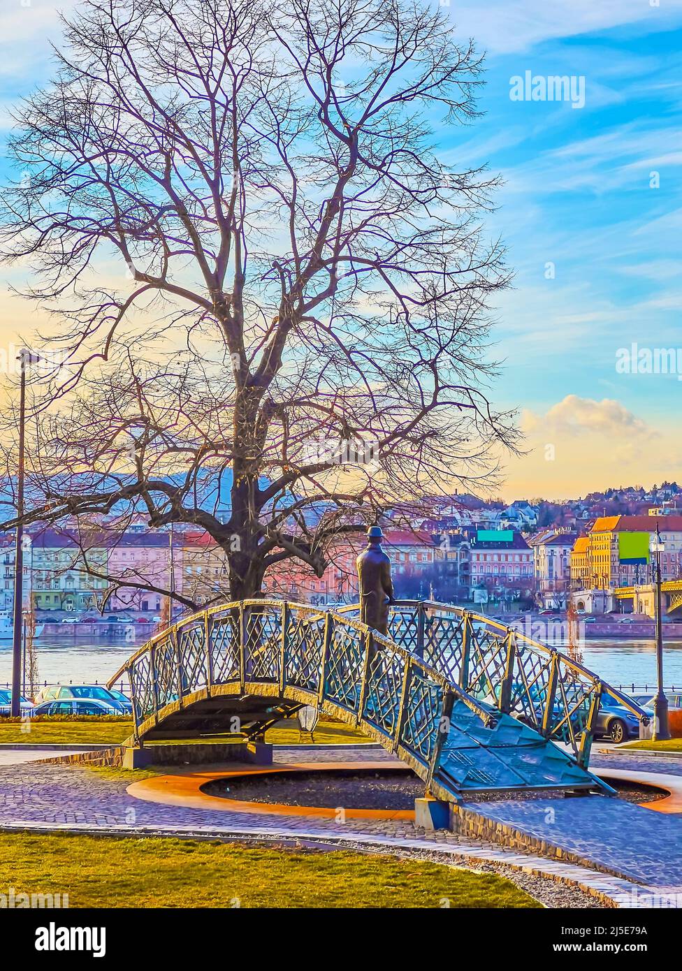The monument to Imre Nagy against the tall spread tree, Danube River