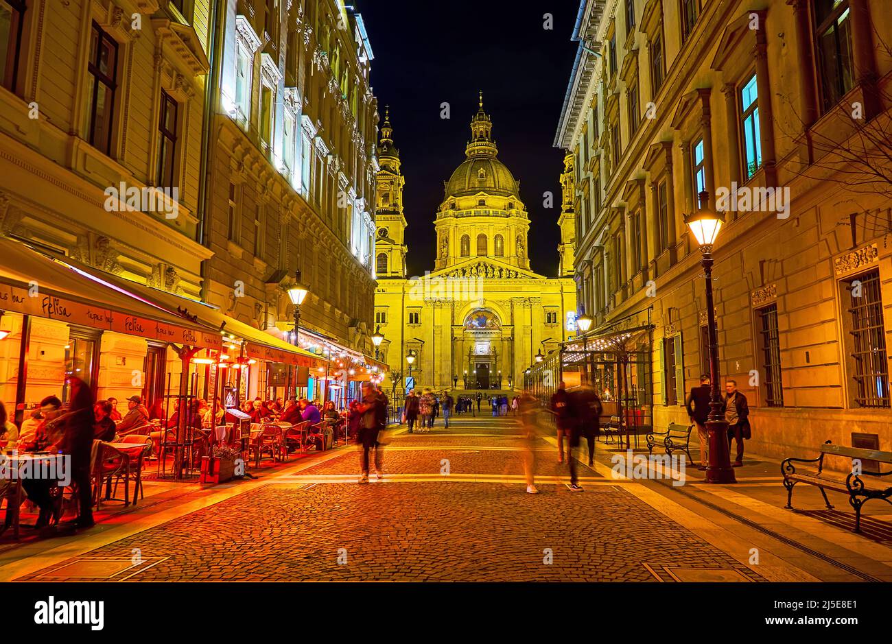 BUDAPEST, HUNGARY - FEB 20, 2022: The view of brightly illuminated St Stephen's Cathedral from pedestrian tourist Zrinyi Street, on Feb 20 in Budapest Stock Photo
