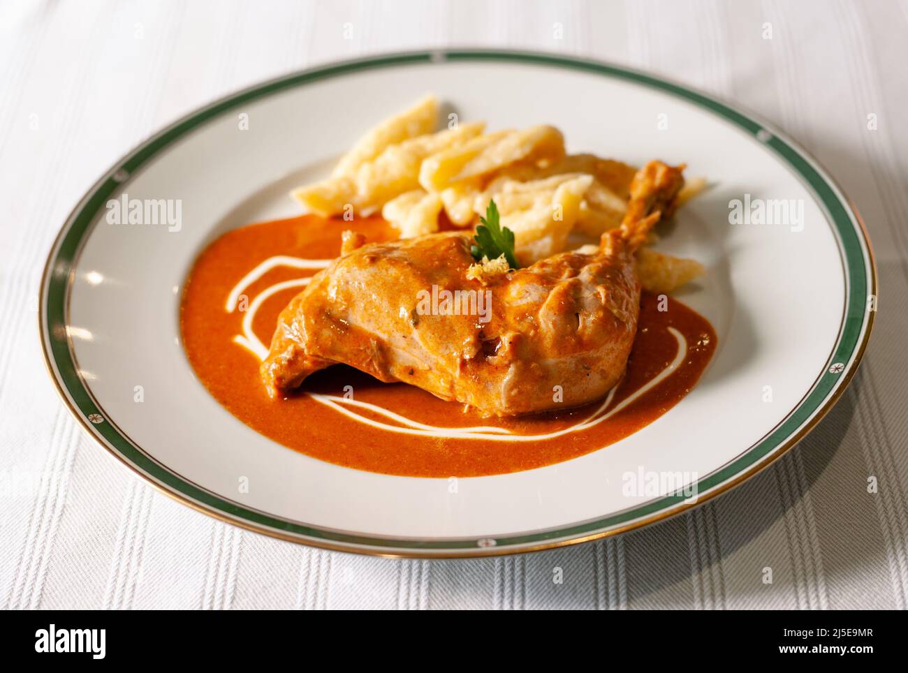 Hungarian Chicken Paprikash with Spaetzle, a Chicken Leg with Paprika Sauce and Small Dumplings Stock Photo