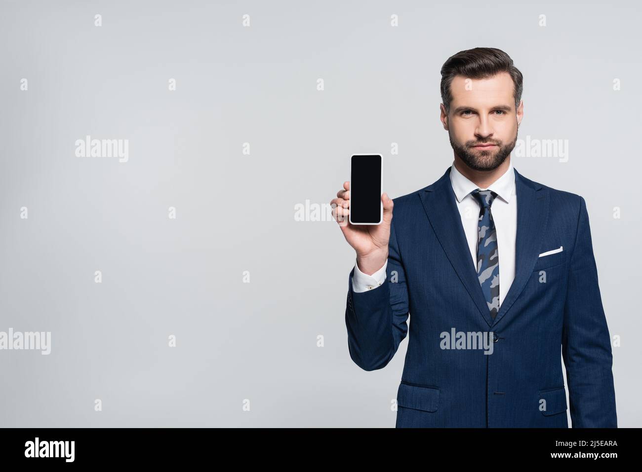 economist in formal wear showing cellphone with blank screen isolated ...