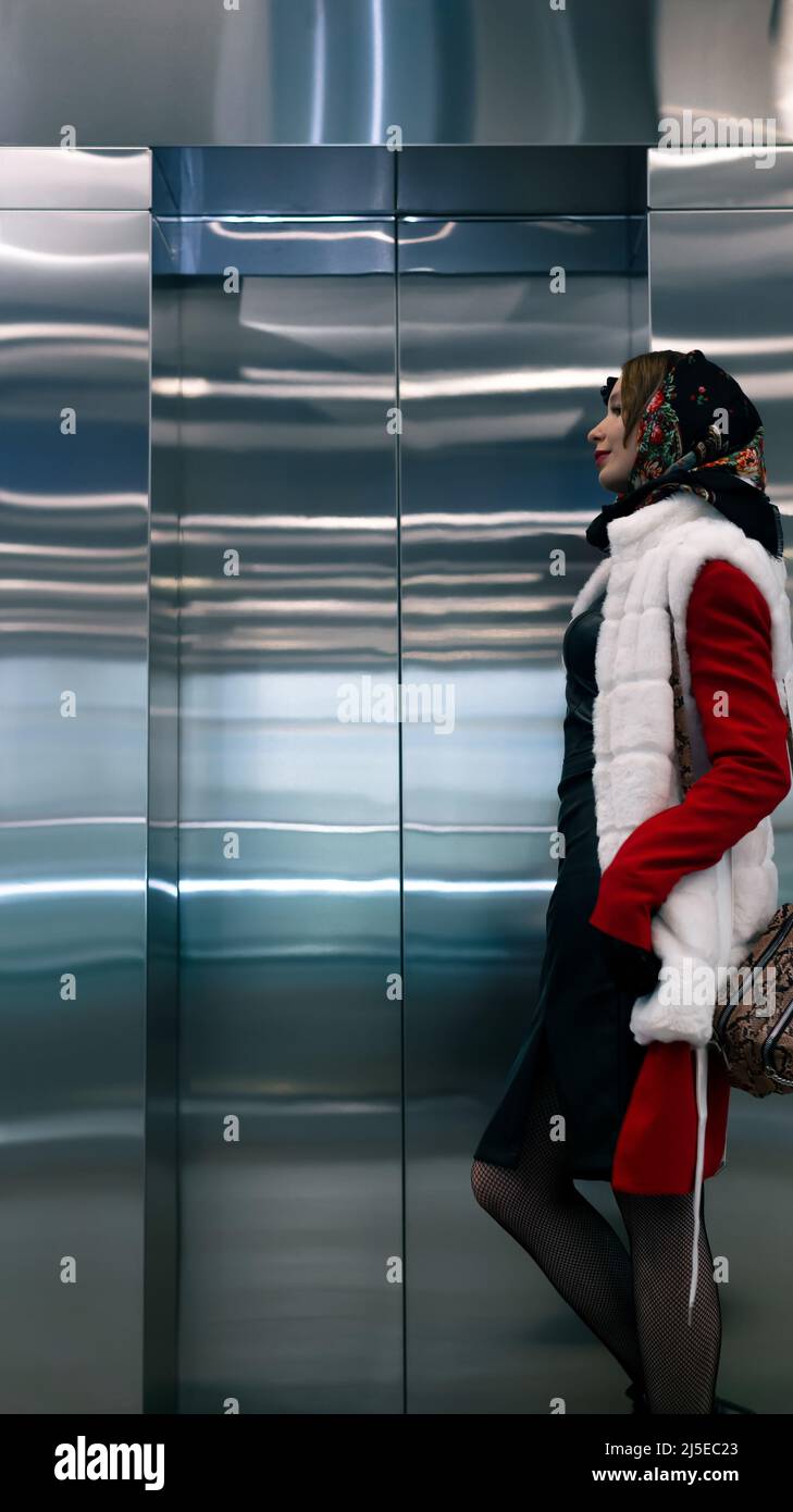 young woman standing waiting for an elevator Stock Photo