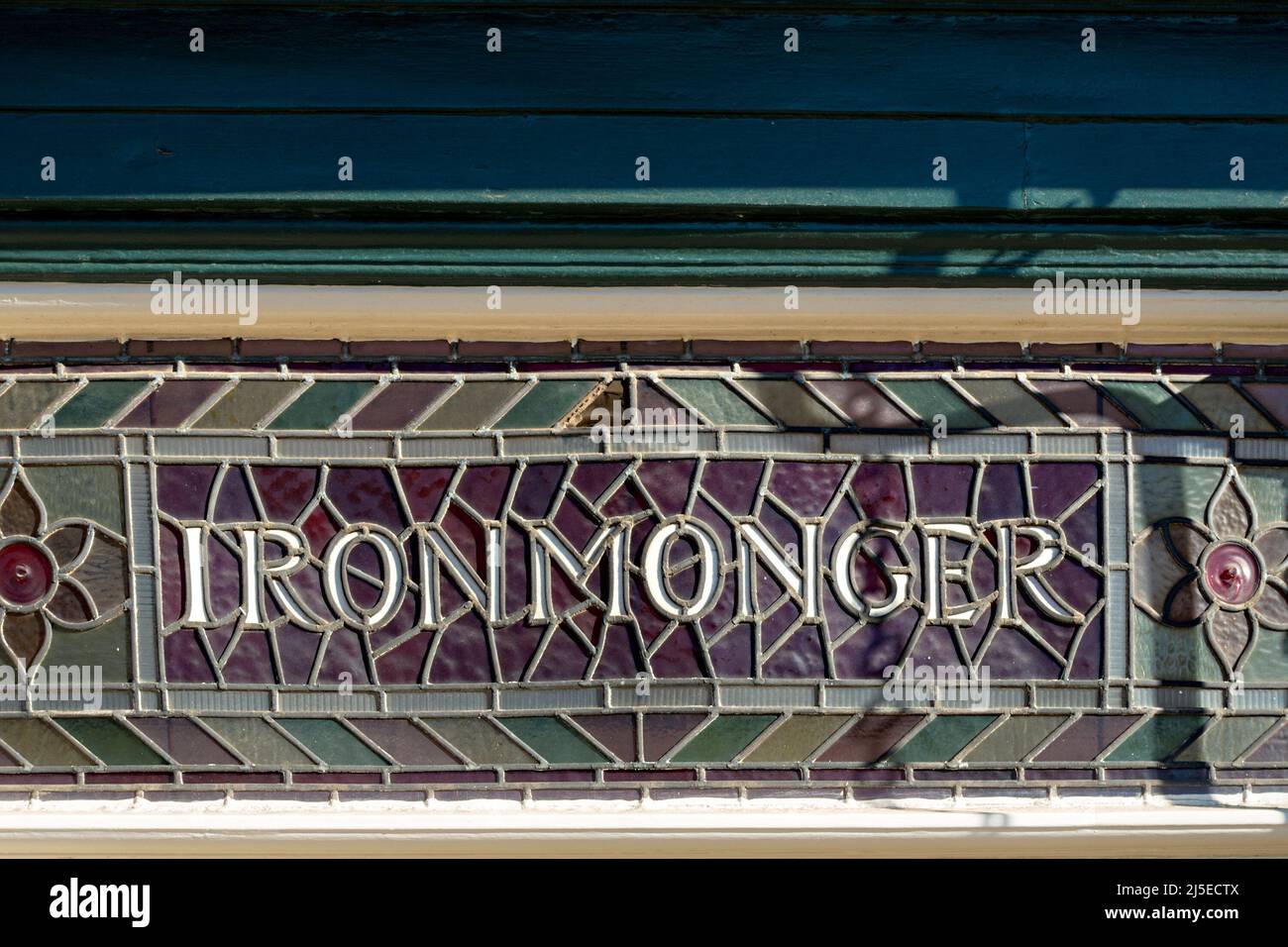 Old stained glass ironmonger shop sign detail, Norton and Son traditional hardware shop, Uppingham, Rutland, England, UK Stock Photo