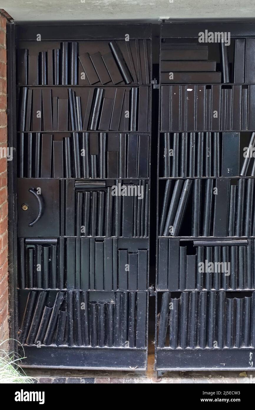 Unusual bookend / bookshelf / bookcase style black metal doors / gates in Printers Yard, Uppingham, Rutland, England, UK Stock Photo