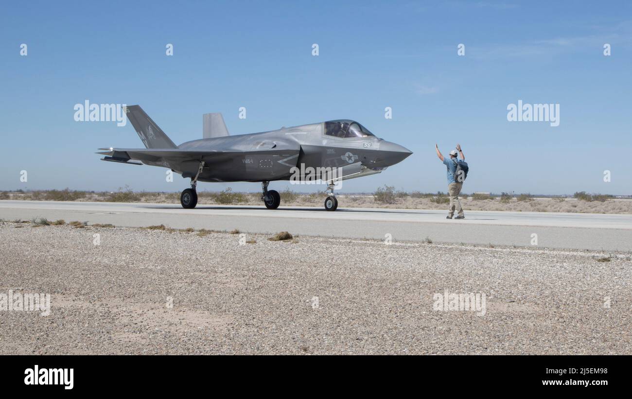Preston Wallace, operations test engineer, Marine Operational Test and Evaluation Squadron 1 (VMX-1), guides an F-35B Lightning II pilot during an Expeditionary Advanced Base Operations (EABO) risk reduction effort on Marine Corps Air Station Yuma, Arizona, March 24, 2022. The purpose of the EABO risk reduction effort was to inform flight clearance operations for short landings and take offs on prepared and semi-prepared surfaces in support of Operation OBSIDIAN ICEBERG. (U.S. Marine Corps photo by Lance Cpl. Jade Venegas) Stock Photo