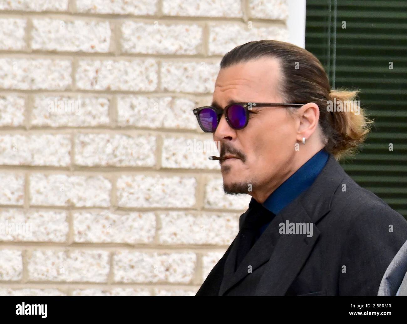 Johnny Depp smokes a cigarette as he returns from a break in his defamation  trial against Amber Heard at the Fairfax County Courthouse in Fairfax,  Virginia on Thursday, April 21, 2022.Credit: Ron