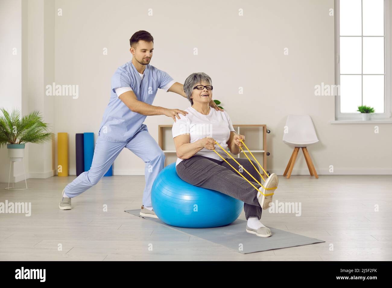 Physiotherapist help mature woman patient with recovery Stock Photo