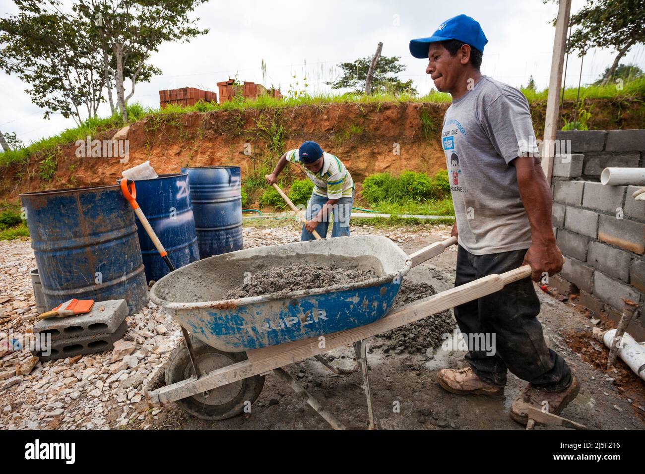 Two men are mixing cement, sand, and water into a good concrete mix to be used to build a house in the Cocle province, Republic of Panama. Stock Photo