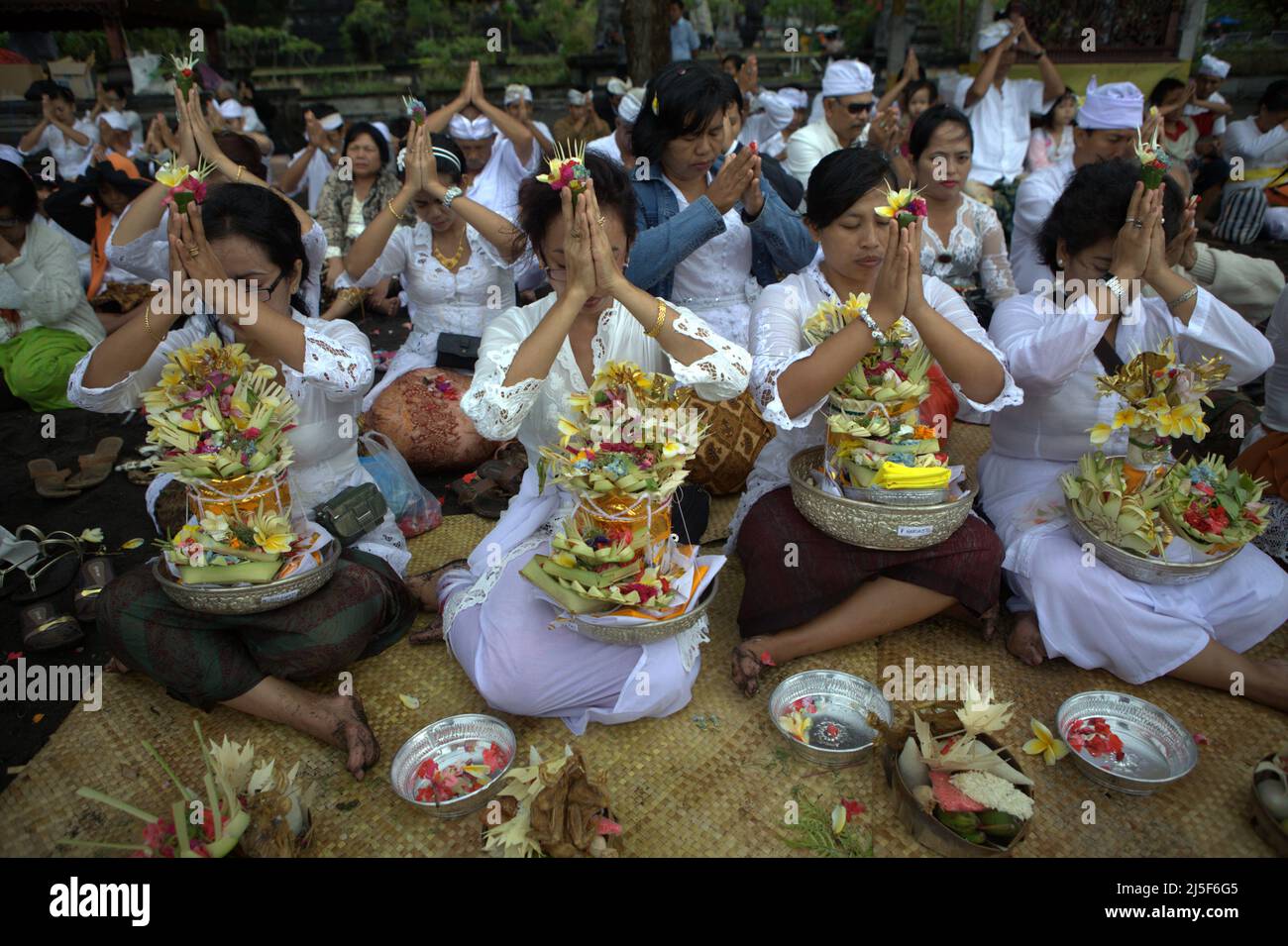 A Balinese clan is praying for their late relatives during a ritual on ...
