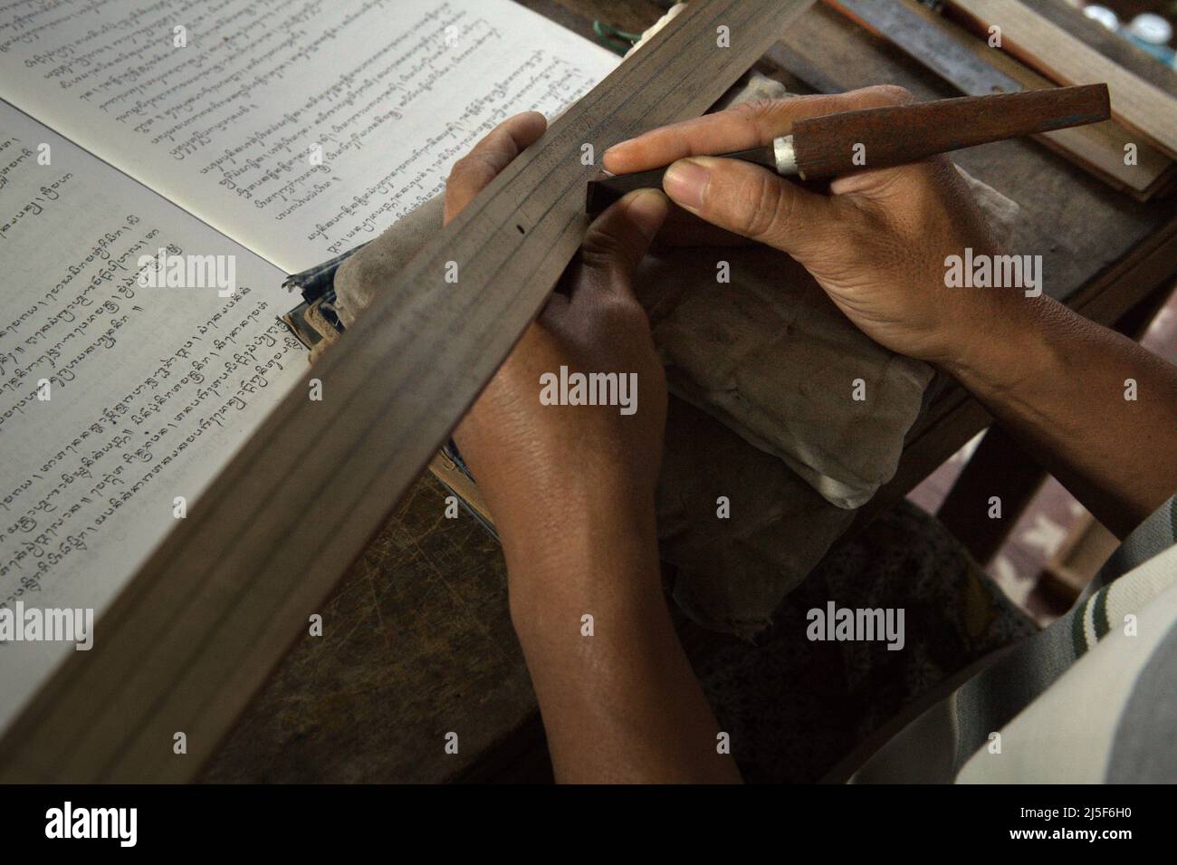 I Wayan Edi Wistara, a Balinese palm-leaf manuscript practicioner, is rewriting old Balinese texts onto palm leafs at his house in Karangasem, Bali, Indonesia. 'Lontars were written in the ancient literary texts composed in the old Javanese language of Kawi and Sanskrit. Balinese script is considered to be one of the complex scripts from Southeast Asia,' wrote a team of scientists led by Made Windu Antara Kesiman (Laboratoire Informatique Image Interaction, University of La Rochelle), during the 15th International Conference on Frontiers in Handwriting Recognition 2016 in Shenzen, China. Stock Photo