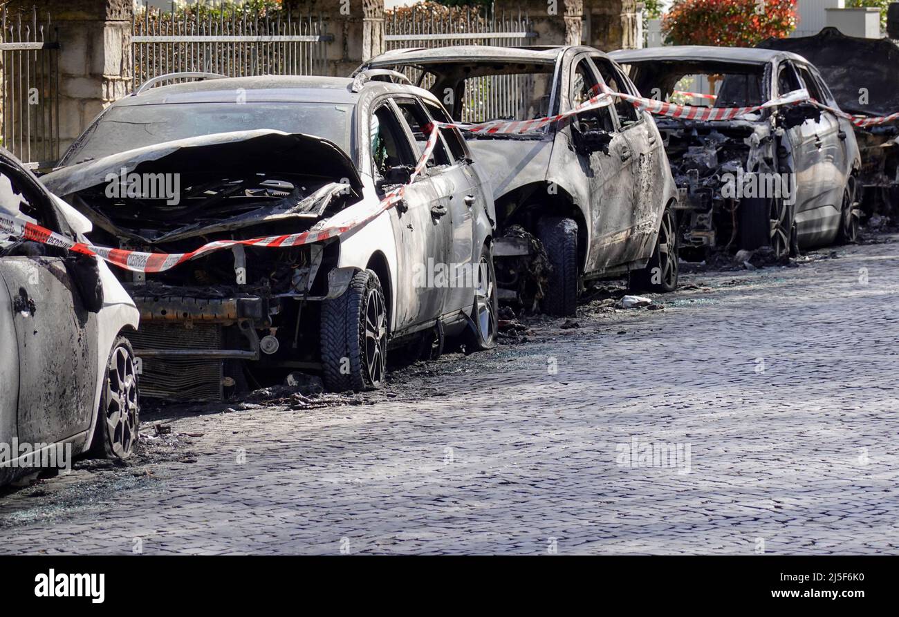 burnt out car wrecks in residential street after vandalism in Germany Stock Photo