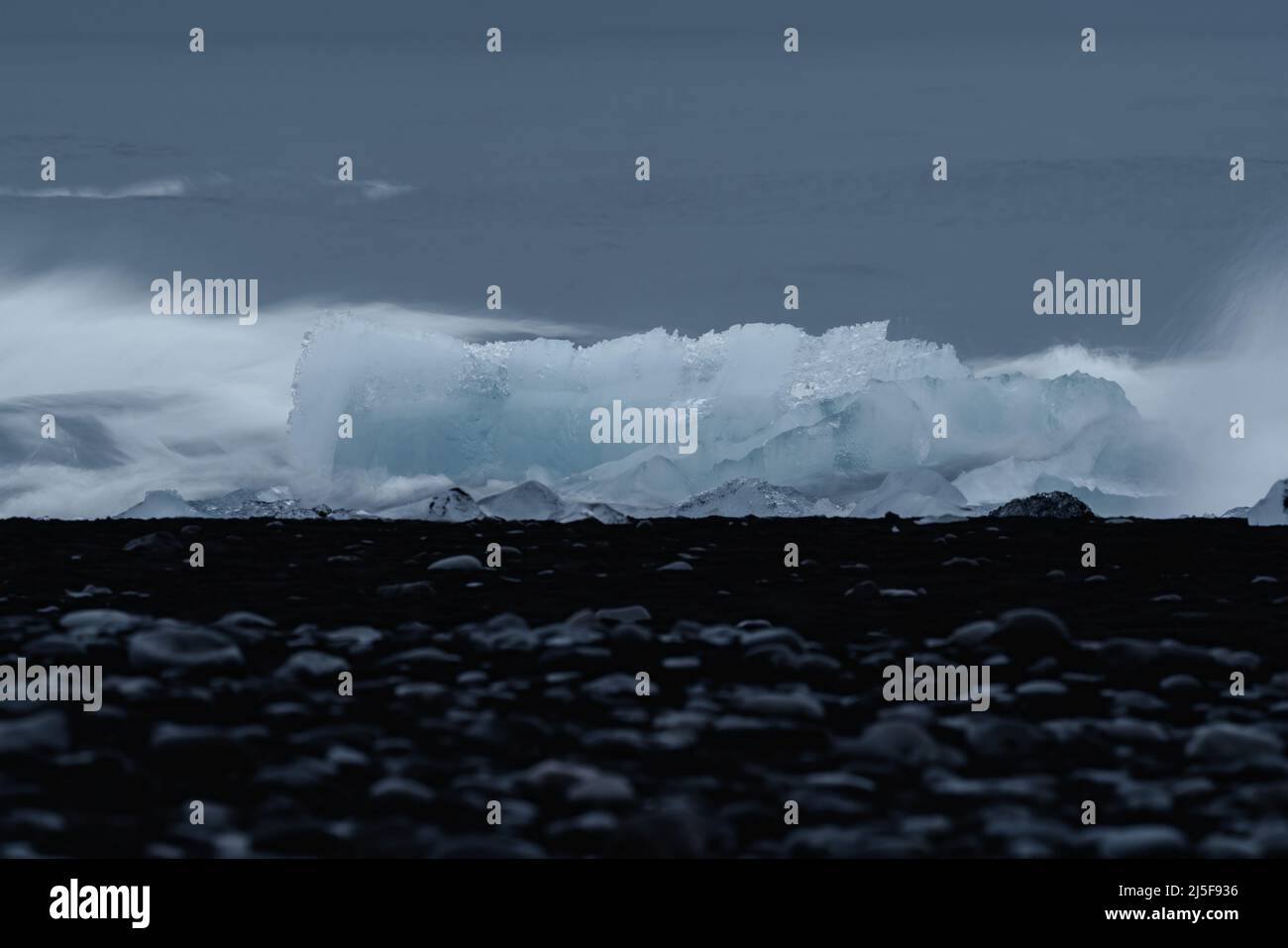 Waves breaking over the iceberg, long exposure Stock Photo