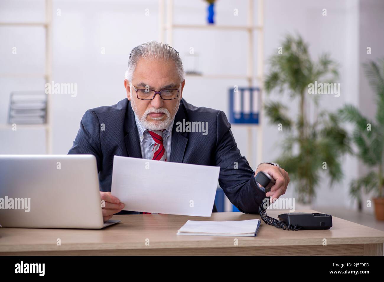 Old businessman employee working at workplace Stock Photo - Alamy