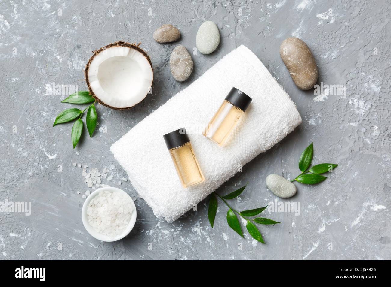 Coconut with jars of coconut oil and cosmetic cream on colored background. Top view. Free space