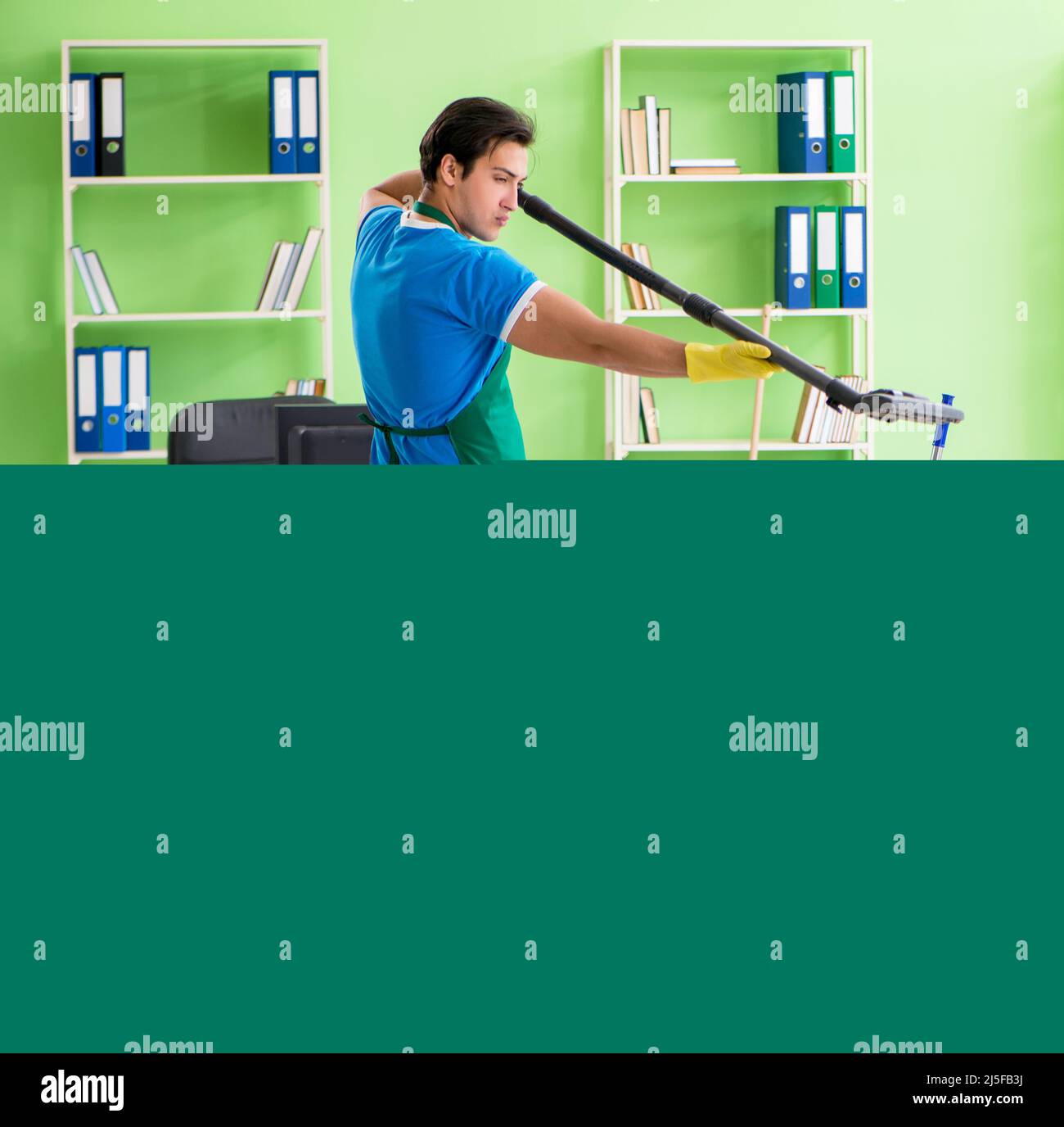The handsome man cleaning office with vacuum cleaner Stock Photo Alamy