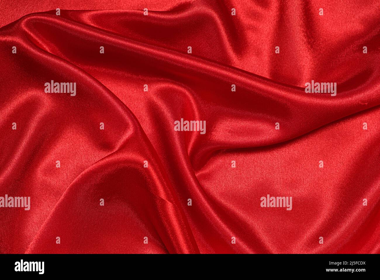 Texture of crumpled red satin fabric, beautiful pattern. Stock Photo