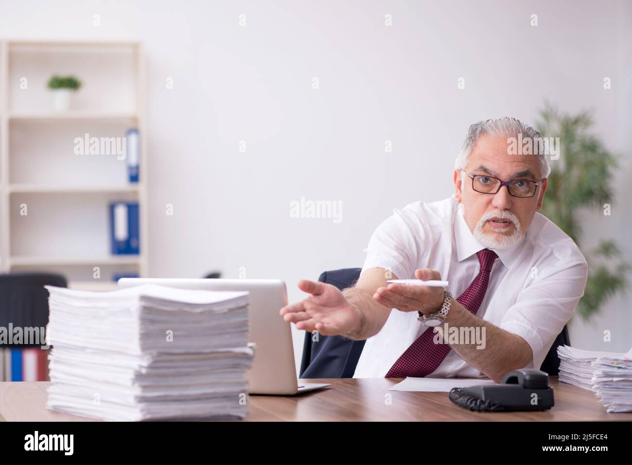 Old employee and too much work in the office Stock Photo Alamy