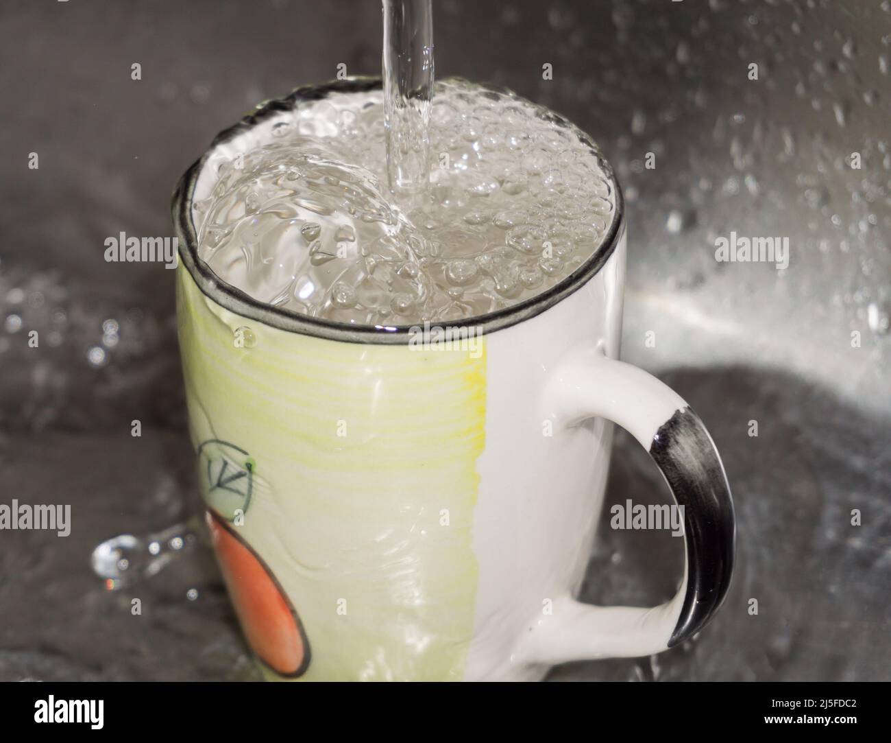 Wasting coming down to a cup, overflowing on the sink Stock Photo