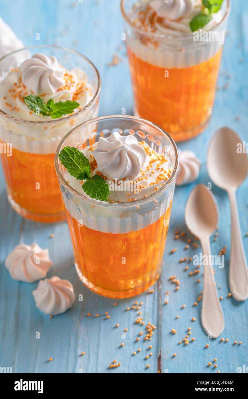 Creamy and delicious orange jelly with small mandarins and cream. Jelly with whipped cream and