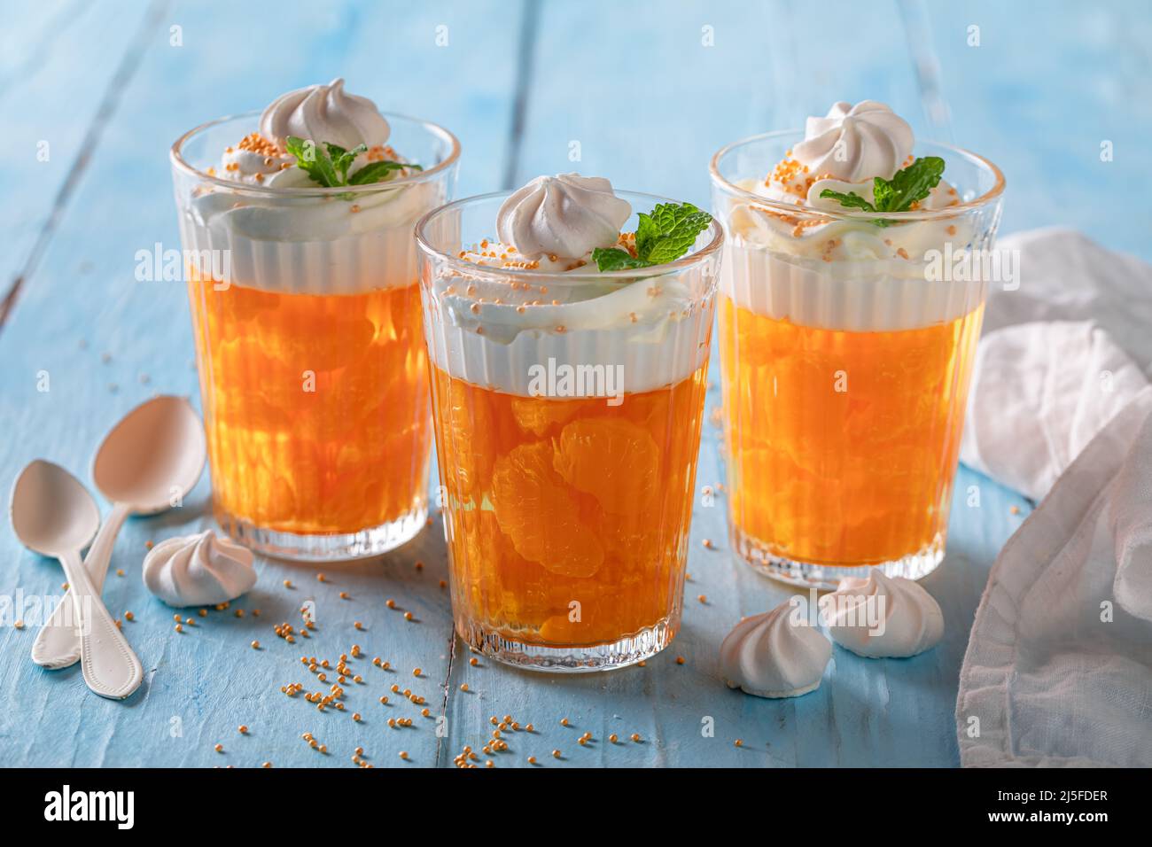 Fresh and sweet orange jelly with small mandarins and cream. Mandarins jelly with whipped cream