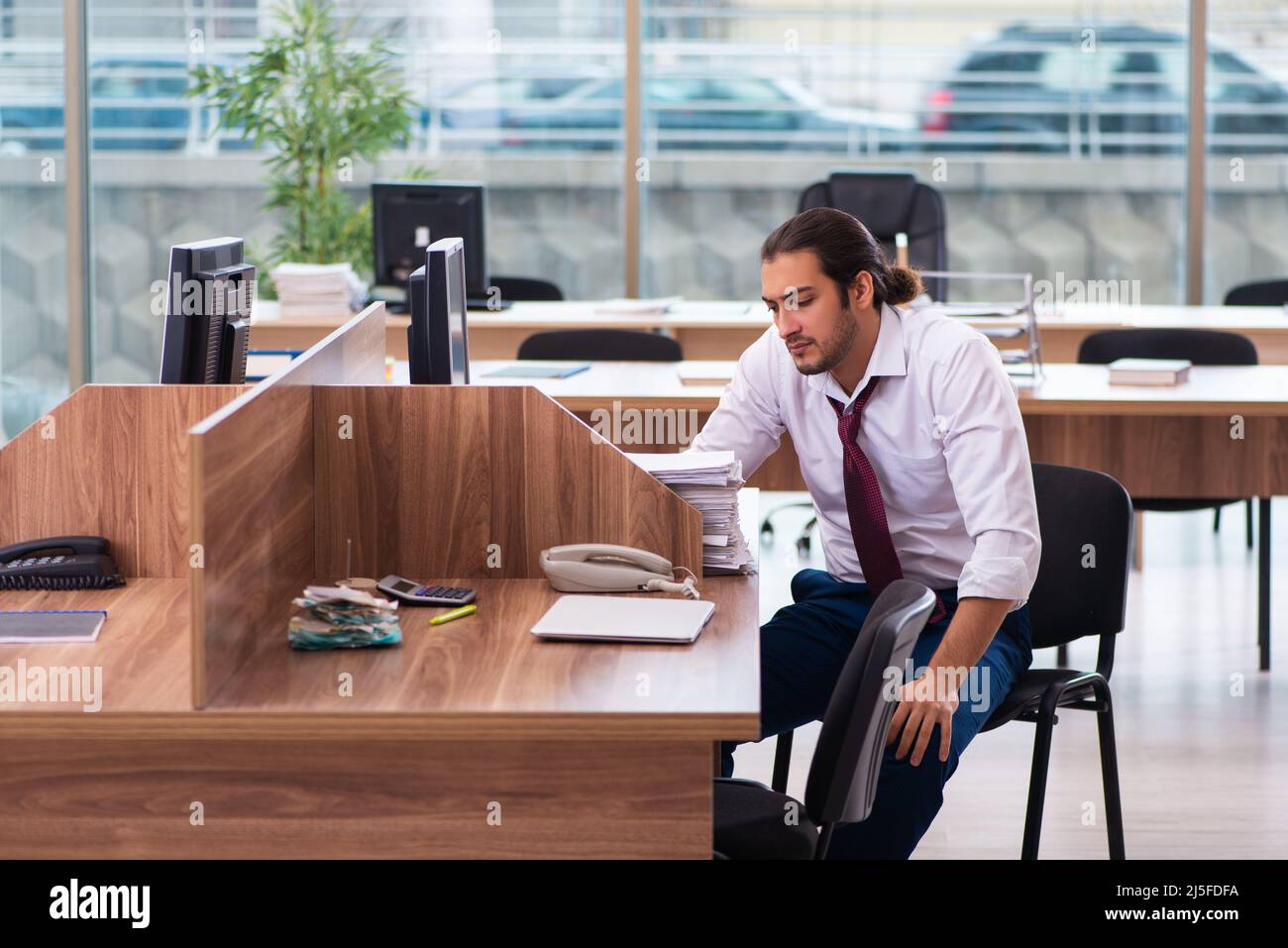 Young employee and too many work in the office Stock Photo - Alamy