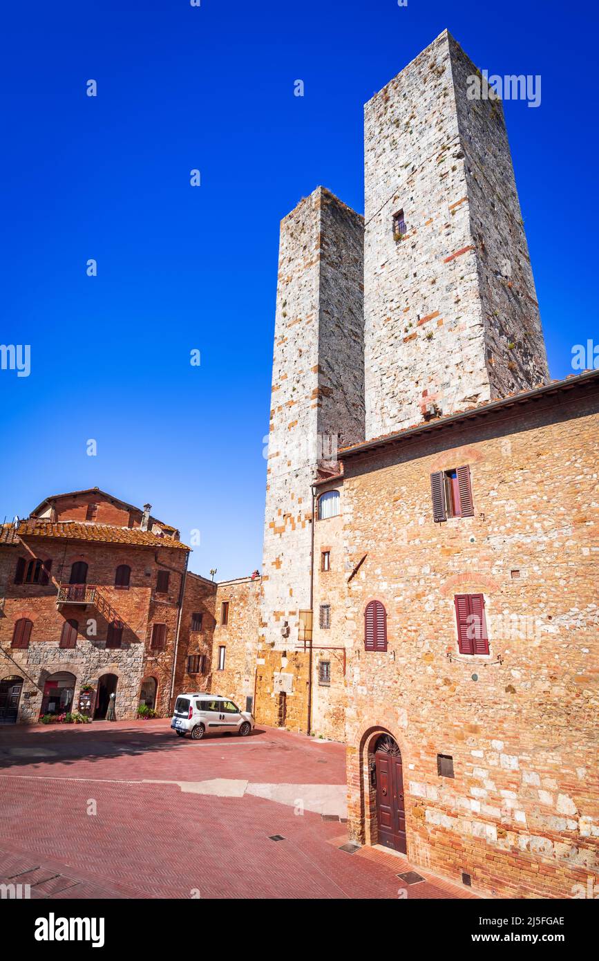 San Gimignano, Italy. Piazza delle Erbe and Torri dei Salvucci, famous small walled medieval hill town in the province of Siena, Tuscany. Known as the Stock Photo