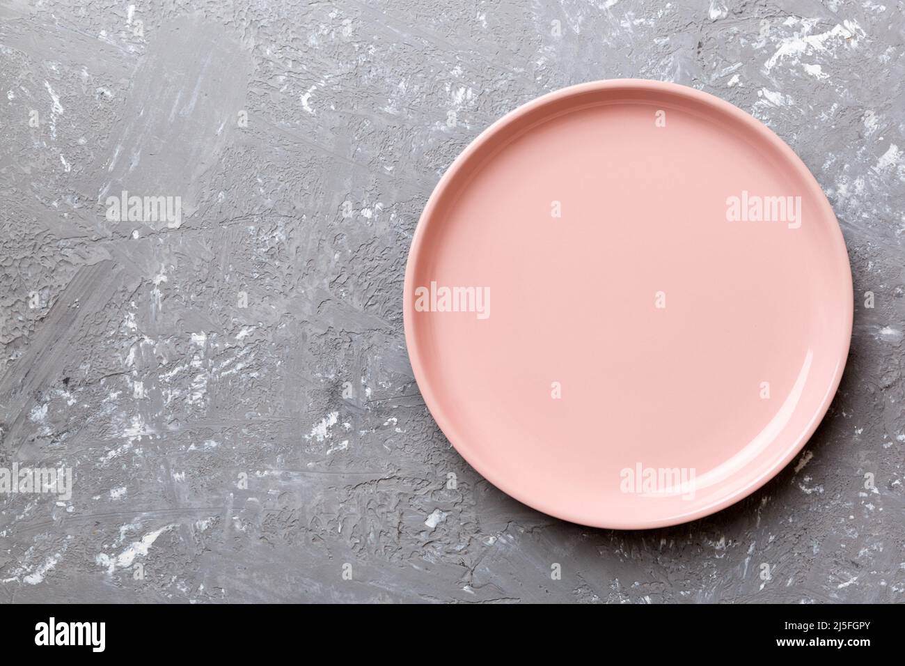 Top view of empty pink plate on cement background. Empty space for your ...