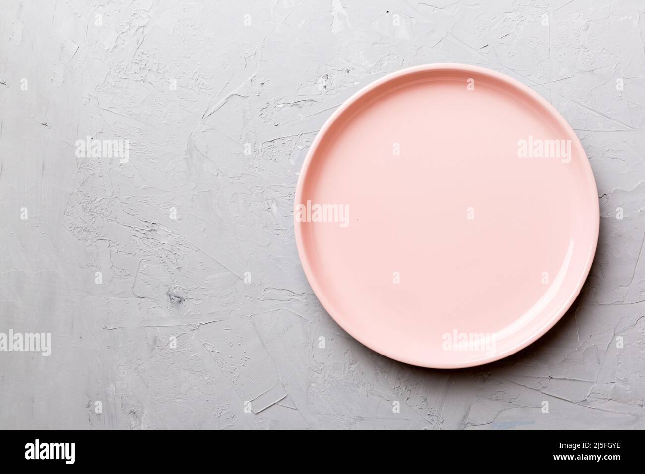 Top view of empty pink plate on cement background. Empty space for your ...