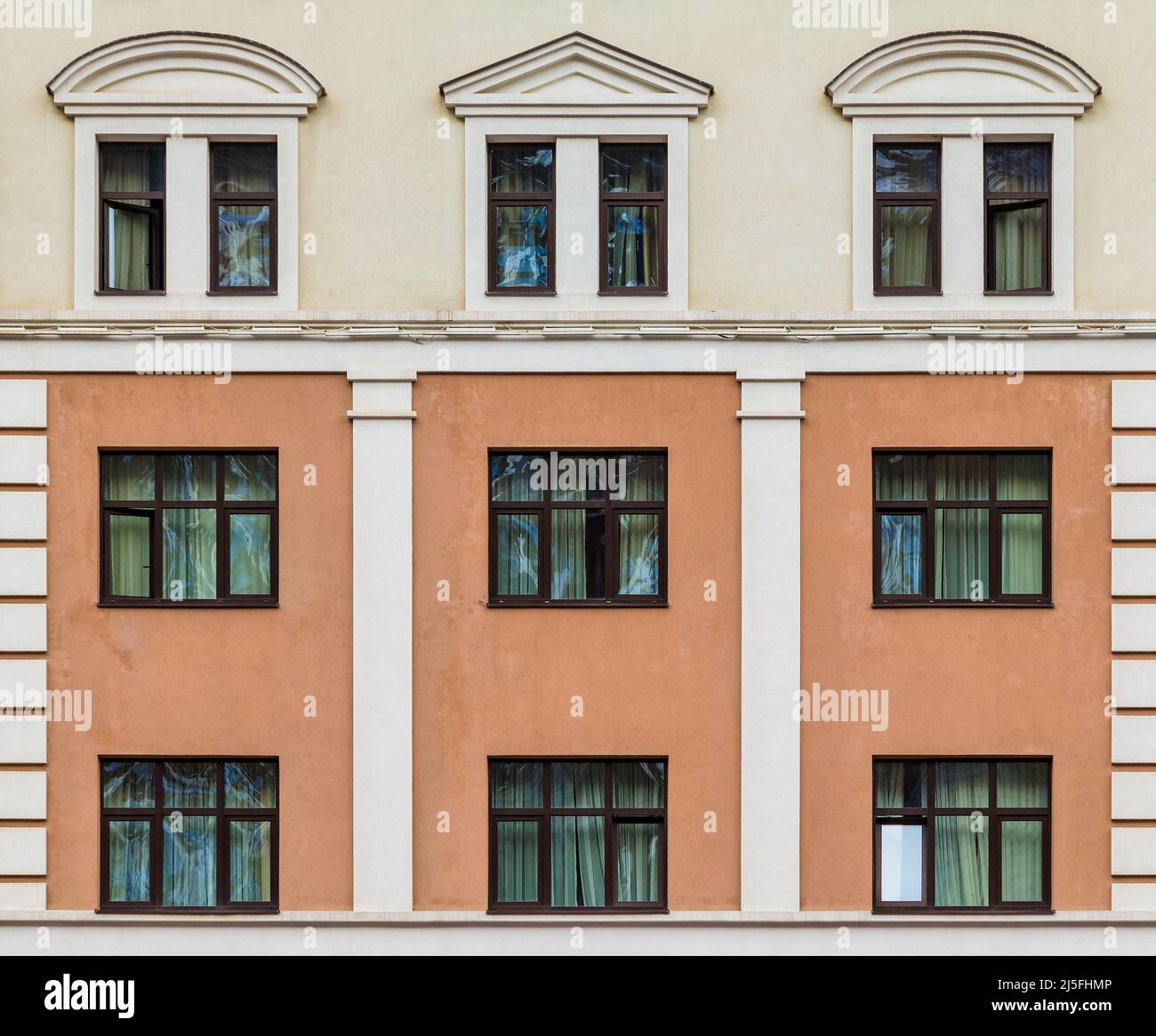 Many windows in a row on the facade of the modern urban apartment building front view, Krasnaya Polyana, Sochi, Krasnodar Krai, Russia Stock Photo